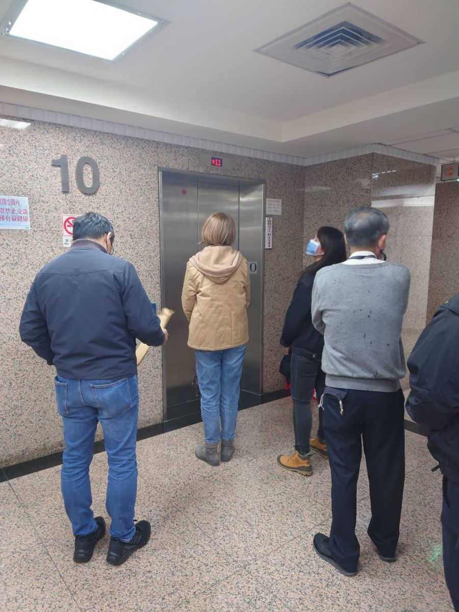 檢調分兩批帶走,第一批帶走辦公室主任陳奐宇,第二批為行政主任(中間棕色外套女子)。蘇聖怡攝