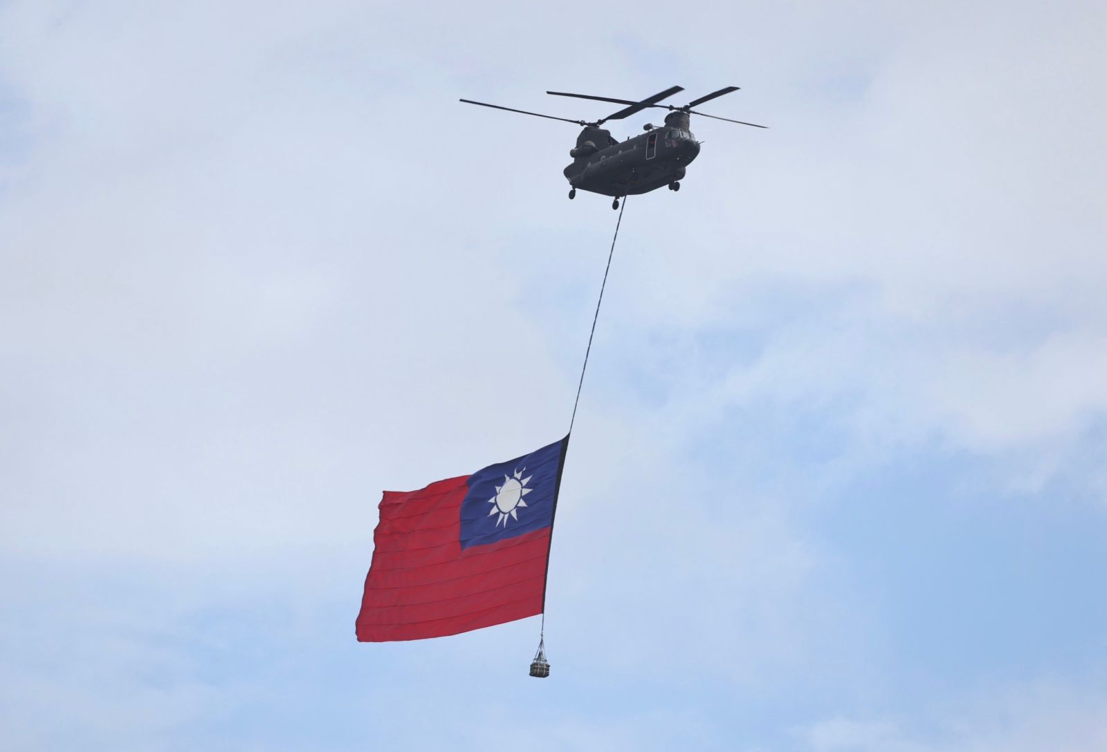 巨幅國旗在2架UH-60M黑鷹直升機護衛下,通過府前廣場。林啟弘攝