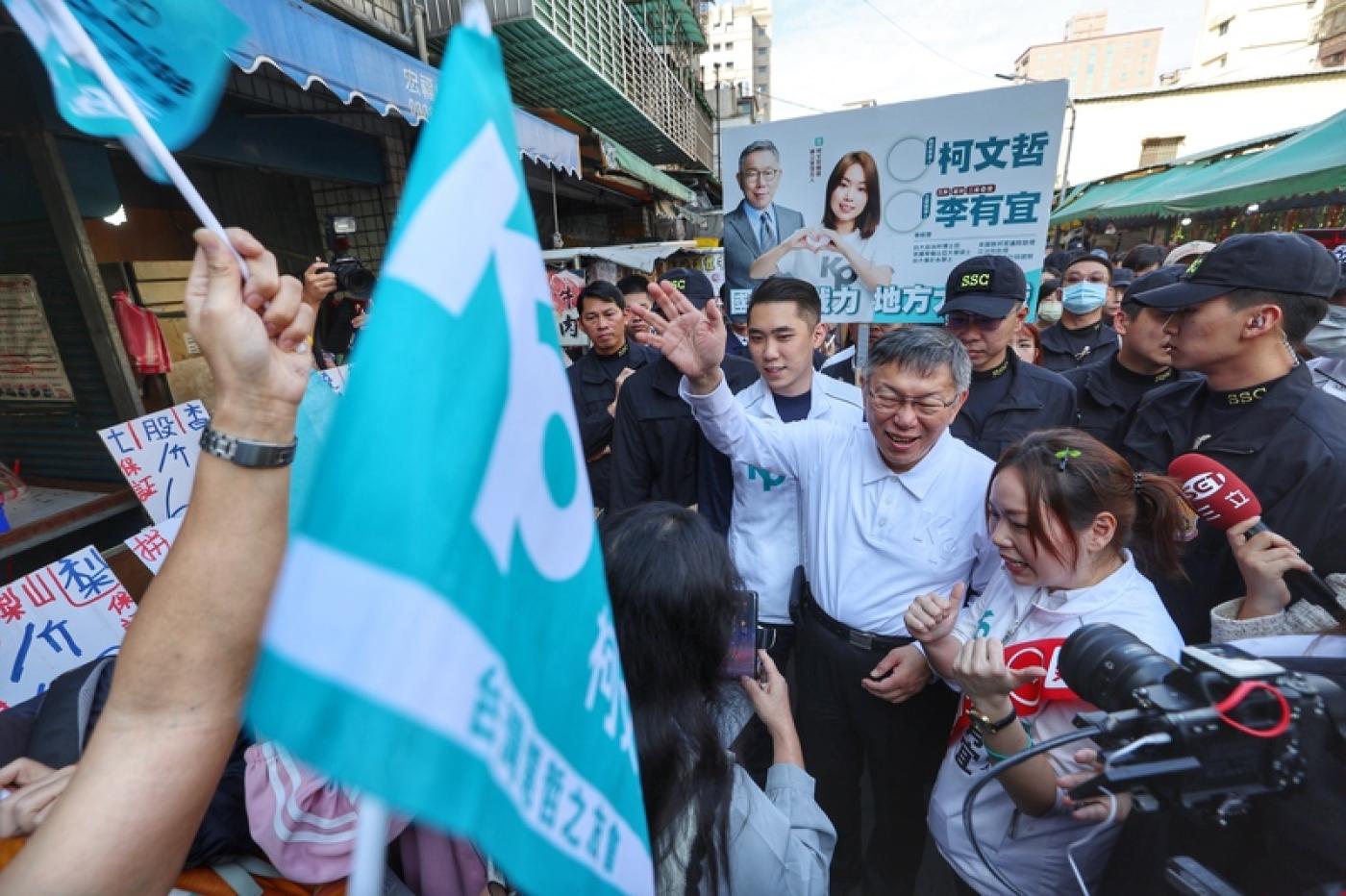 柯文哲（前右2）與立委參選人李有宜（前右）9日上午到新北市蘆洲水流公市場掃街拜票，現場支持者搖旗高喊「凍蒜」口號。中央社